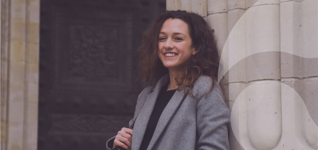 young woman smiling, looking at us