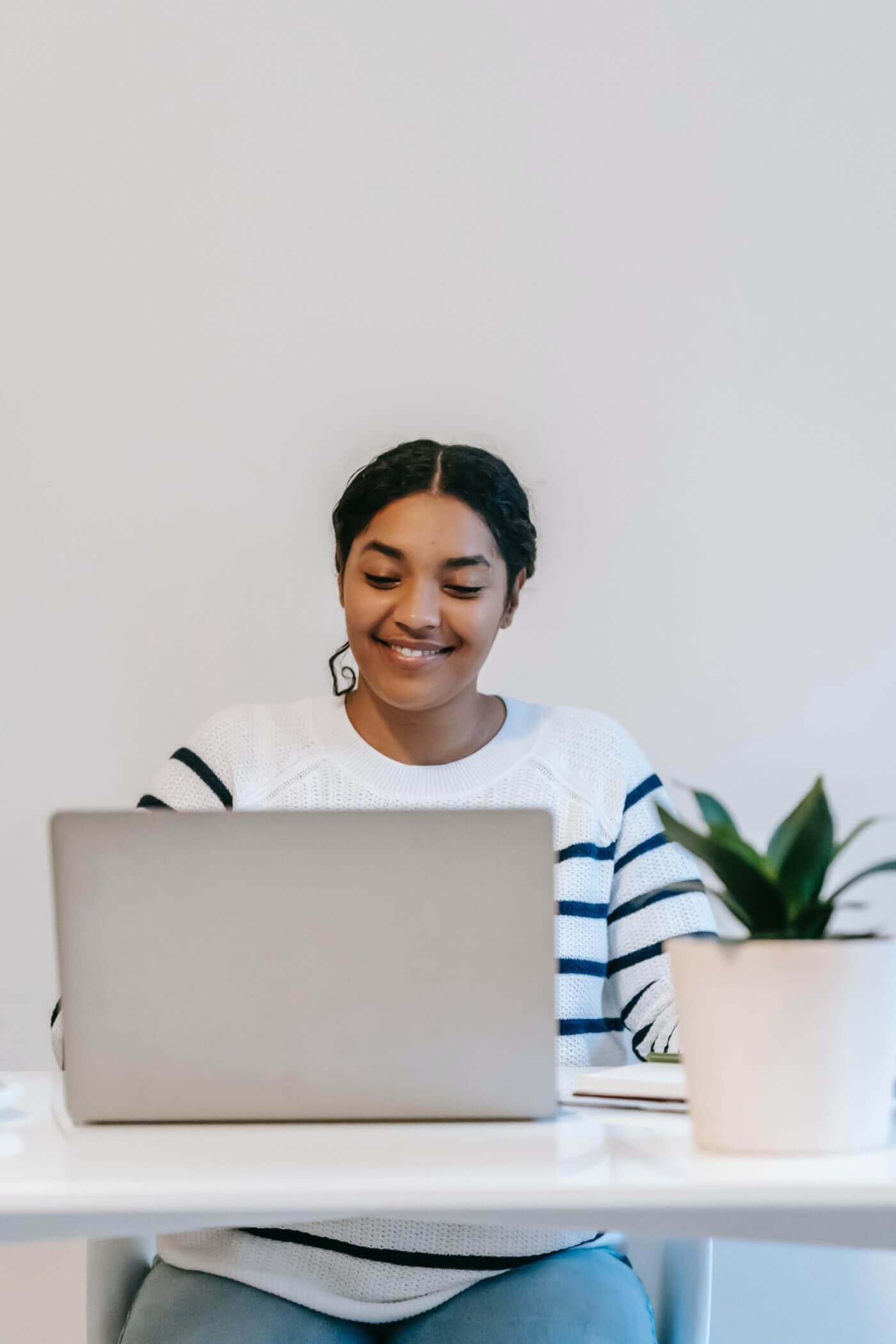 a happy young woman working on a laptop