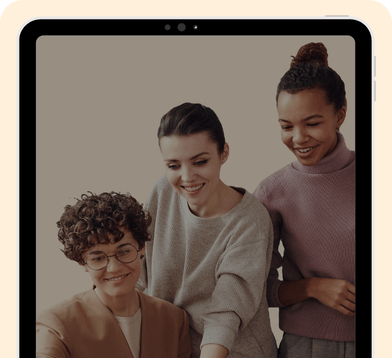 3 young women smiling and looking together at something