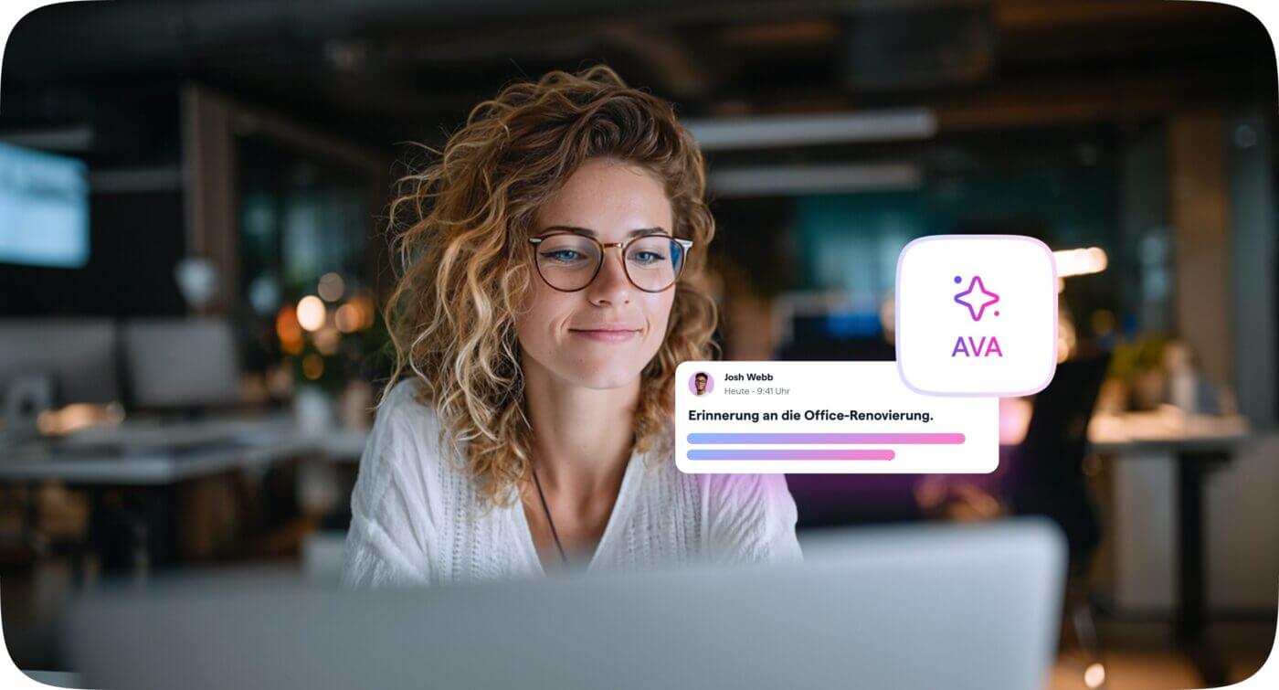 KI für interne Kommunikation: Frau mit Brille arbeitet am Laptop im modernen Büro, daneben eine Nachrichtenerinnerung, generiert von Haiilo AVA.
